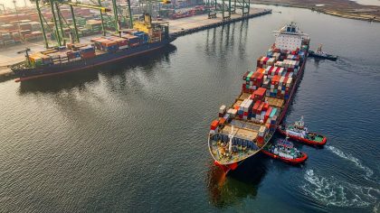 red and blue cargo ship on body of water during daytime